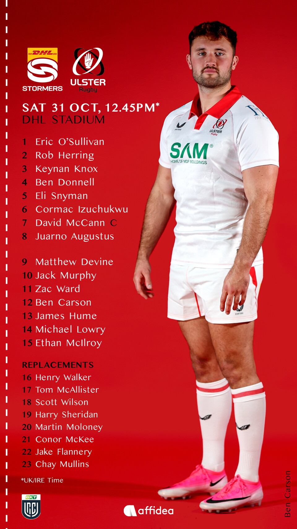 A rugby player stands on a red background wearing a white shirt with red trims.