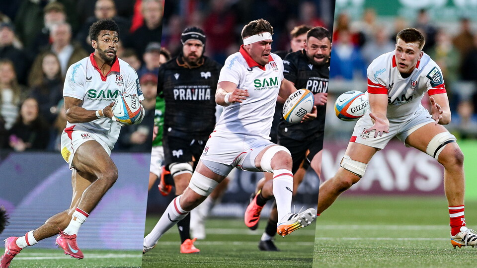 Three rugby players on a field, one running, one chasing, one kicking, with spectators in the background.