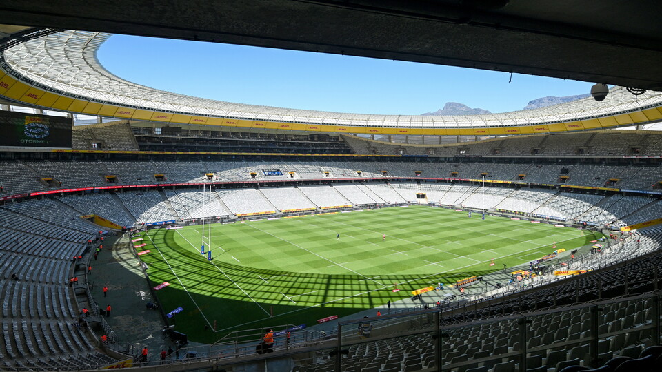 Stadium with green pitch and blue sky