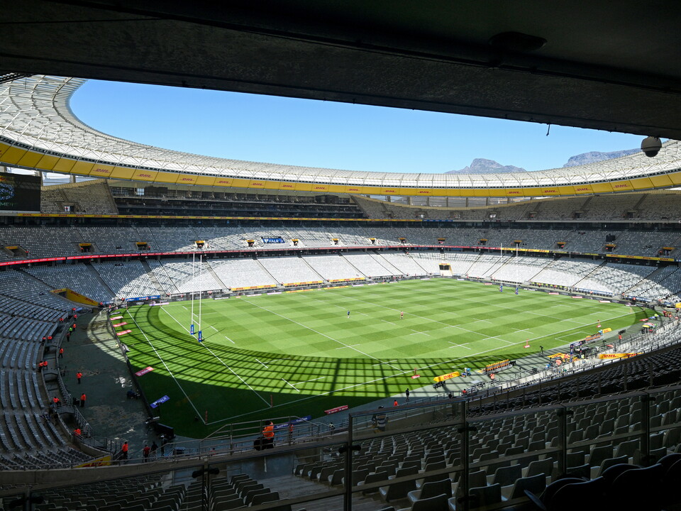 Stadium with green pitch and blue sky